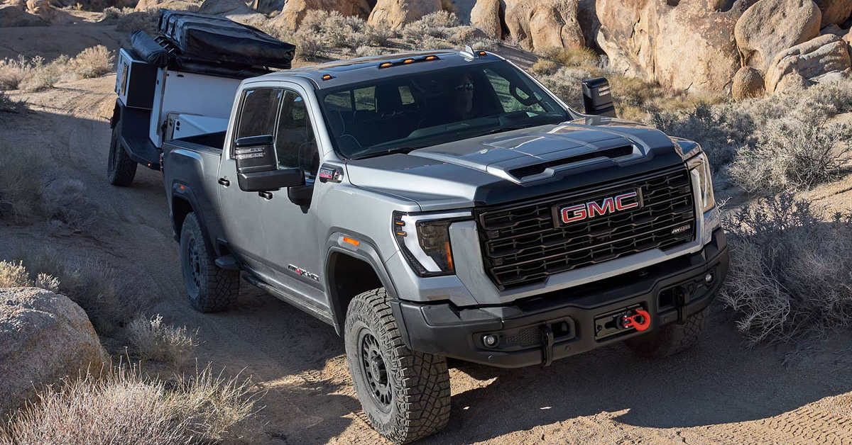2026 GMC Sierra HD - towing massive off-road vehicle on rugged trail