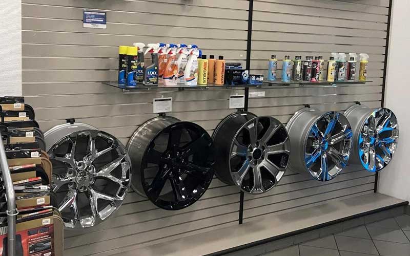 A wall display of wheel rims and cleaning supplies