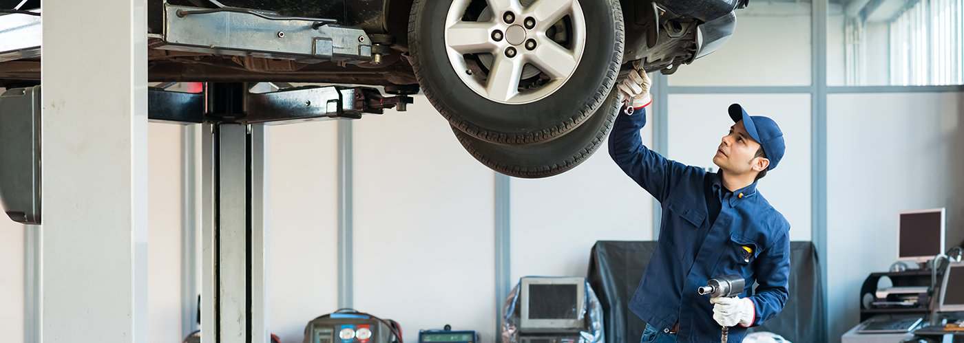 a service man inspecting car in front tire